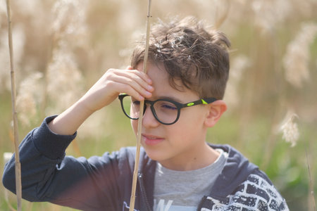 portrait of little boy with glasses in nature. High-quality photoの写真素材