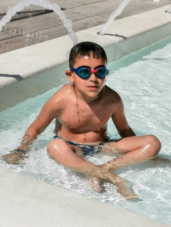 child with swimming goggles plays in the water. High-quality photoの写真素材