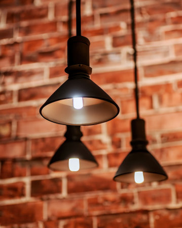 Many pendant lamps against red old brick wall. High-quality photoの写真素材