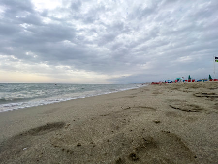 beach footprints in Romagna with open umbrella in summer. High-quality photoの写真素材