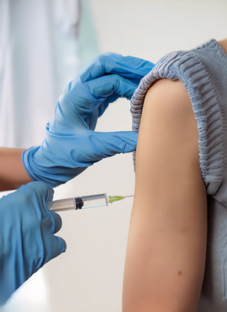 Doctor with syringe making injection to female patient, close-upの素材