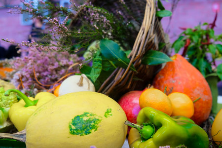 An assortment of natural foods like leafy green vegetables, yellow peppers, and various fruits are arranged on the table, ready to be used as ingredients in a delicious recipeの写真素材