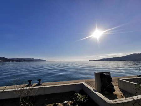 The sun is shining brilliantly and vibrantly over the vast ocean, casting its warm light and creating a beautiful scene along the coastの写真素材