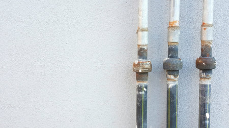 Three cylindrical pipes, made of different metals including silver and nickel, are neatly lined up...