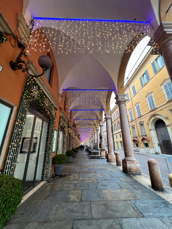 A captivating shot of the illuminated porticoes of Bologna, adorned with festive lights. The image...