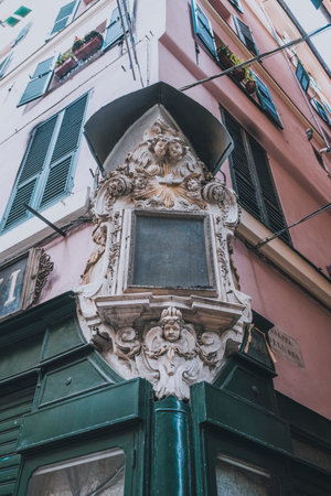 An ornate votive niche with religious imagery affixed to the corner of a traditional building, showcasing its cultural significance and artistic details.の写真素材