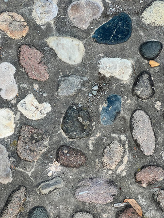 A close-up shot of a pebble mosaic floor, showing the intricate arrangement of small stones in...