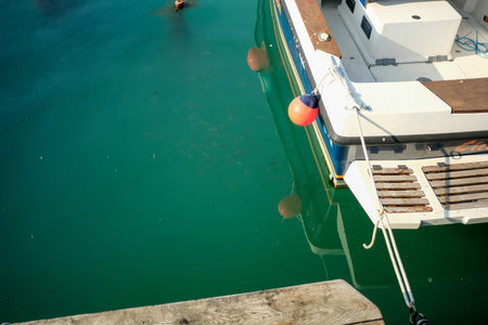 A view of a boat docked at a pier, highlighting the rustic charm of wooden planks and the...