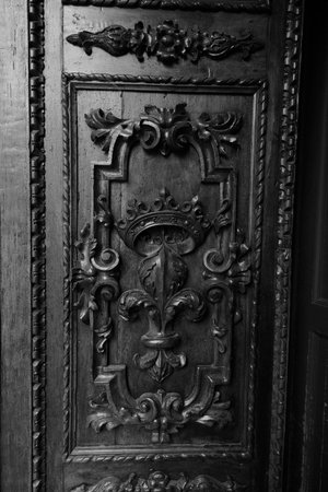A close-up shot of an ornate door in black and white, highlighting its intricate details and texture.の写真素材