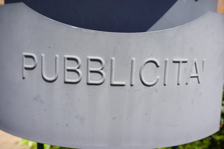 A close-up of a public sign with the word PUBBLI CITA inscribed, indicating a communal area or...