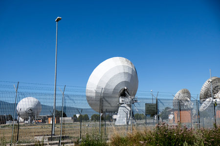 A wide shot of multiple large white satellite dishes at the Telespazio Fucino Space Centre, set...