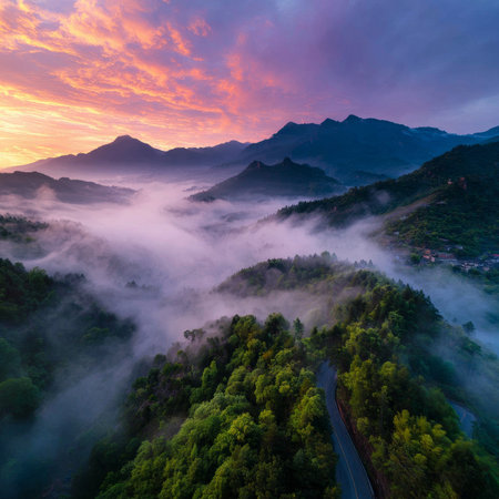 A stunning, atmospheric mountain landscape at sunrise or sunset, featuring thick fog clinging to the forest with a colorful sky in shades of purple and pink. Evokes a peaceful feeling. High quality photoの素材