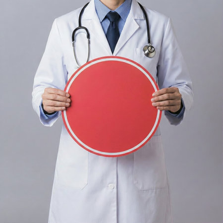 Man doctor wearing a white coat and stethoscope holding a blank red circular sign, symbolizing health, warning, and medical concepts. High quality photoの素材