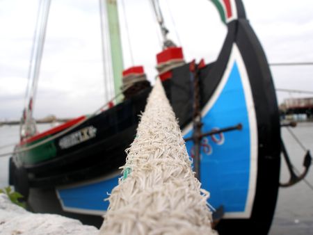 Colorful wood fishing boat with its anchor hangingの写真素材