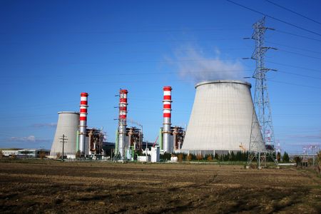 Power plant chimneys producing white smoke against a blue skyのeditorial素材