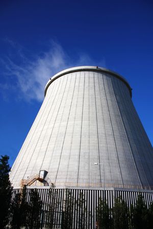 Power plant chimney producing white smoke against a blue skyのeditorial素材