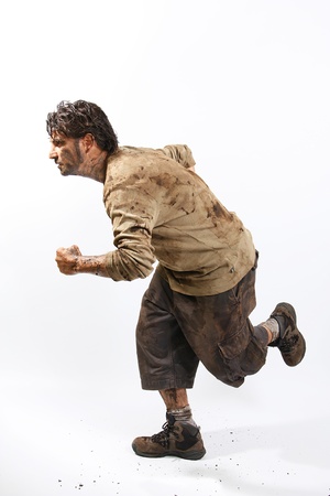 A man covered in mud running, trying to surviveの写真素材