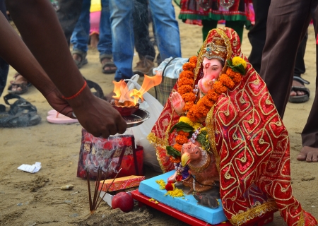 Mumbai, India - September 2013 - Devotee offering flames, fire to Hindu God Ganesha before bringing him into the oceanのeditorial素材