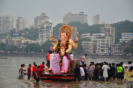 Mumbai, India - September 2013 - Hindu God Ganesha immersing into the ocean with background of cityのeditorial素材
