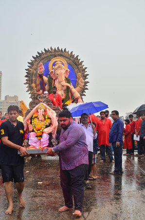 Mumbai, India - September 2013 - Devotees  bringing Hindu God Ganesha into the oceanのeditorial素材