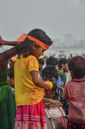 Mumbai, India - September17, 2013 - Young girls standing among crowds on the beach watching devotees pushing Hindu God Ganesha into the ocean during Ganesha Festivalのeditorial素材