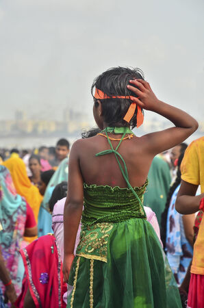 Mumbai, India - September17, 2013 - Young girls standing among crowds on the beach watching devotees pushing Hindu God Ganesha into the ocean during Ganesha Festivalのeditorial素材