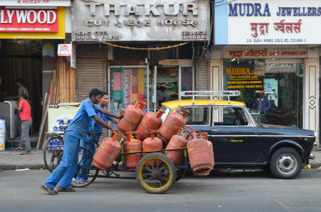 Mumbai, India - December 2013 - Workers delivering LPG gas cylinders on the busy streetのeditorial素材