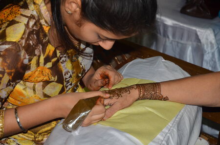 Mumbai, India -  December 2013 - Young lady painting Henna paste on her friendのeditorial素材