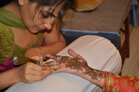Mumbai, India -  December 2013 - Young lady painting Henna paste on her friendのeditorial素材