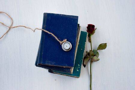 old book rose and locket watch on white backgroundの写真素材