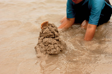 Children playing sand castle at the sea