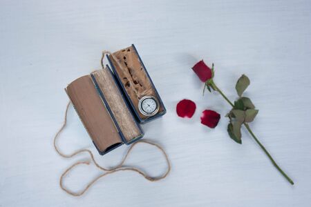 old book rose and locket watch on white backgroundの写真素材