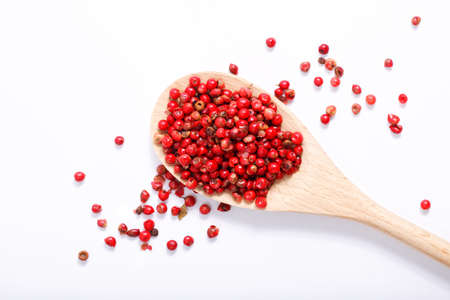 Organic Pink Peppercorn in wooden spoon on white background with copy spaceの写真素材