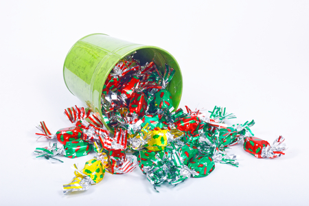 Colorful candy and green bucket on white backgroundの写真素材