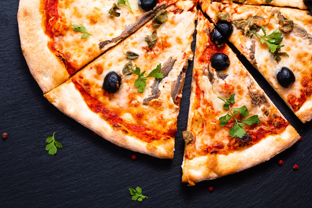 Homemade Napoli Pizza or anchovies pizza on black slate stoneの写真素材