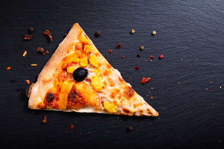 Homemade Chicken curry,black olive and corns Pizza on black slate stone boardの写真素材