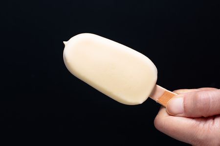 Summer ice cream White chocolate covered vanilla favor bar or pop stick on handの写真素材