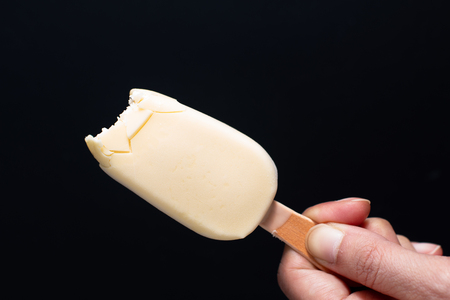 Bitten Summer ice cream White chocolate covered vanilla favor bar or pop stick on handの写真素材