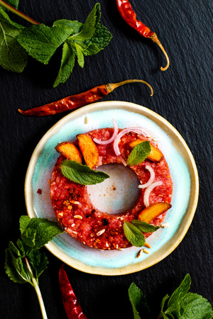 Food concept spicy raw Larb Thai, Beef tartar Thai style on black slate board with copy spaceの写真素材