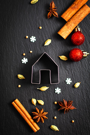 Holiday Food background Christmas cookies cutter spices Star anise, cloves and cadamon pods on black slate boardの写真素材