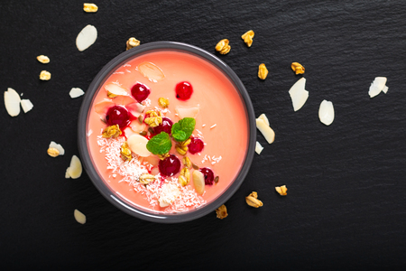Healthy food by color of 2019 living coral Yogurt Breakfast Bowl  with coconut, almond, flax seeds, Granola, and red currants in ceramic bowl with copy spaceの写真素材