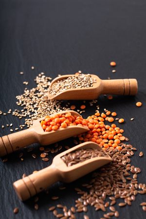 Healthy nutrition food Flax, sesame and orange lentil seeds in bamboo scoop with copy spaceの写真素材