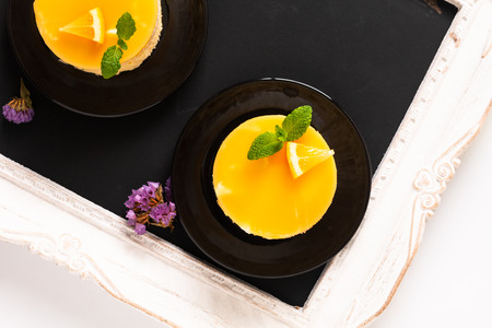 Food concept Homemade Lemon curd sponge cake with fresh whipped cream in black plate with copy spaceの写真素材
