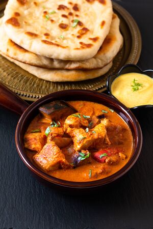Food concept homemade Tandoori Chicken Masala curry with naan bread and yogurt dipping sauce with copy spaceの写真素材