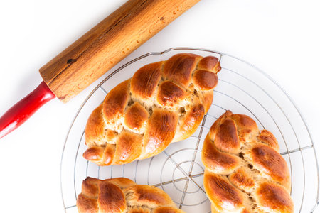 Homemade food concept fresh baked bread braid challah dough on white background with copy space
