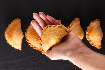 South east Asia origin food concept homemade chicken Curry puffs on black slate stone background...