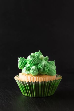 Bakery concept Homemade Sponge vanilla cupcake green tone buttercream on black background with copy spaceの写真素材