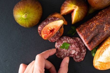 Food concept dried cured sausage on black slate board with copy spaceの写真素材