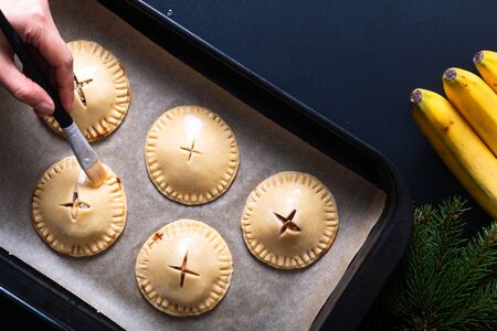 Food concept processing to make Homemade Banana foster hand pie on black backgroundの写真素材