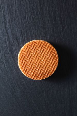 Food Concept Stroopwafel, crispy caramel syrup Dutch waffles  on black slate stone backgroundの写真素材